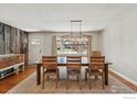 Cozy dining room featuring a long wood table with stylish chairs and a decorative area rug at 13905 W 21St Ave, Golden, CO 80401