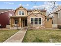 Charming two-story home with a stone facade, covered porch, and well-maintained lawn at 14214 Waterside Ln, Broomfield, CO 80023