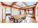Dining room boasts a large wooden table with white walls and wooden beams in the ceiling at 174 N Cedar Brook Rd, Boulder, CO 80304