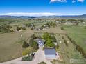 Aerial view showcases the home, barn, and scenic mountain views at 2610 W County Road 4, Berthoud, CO 80513