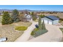 Aerial view of a charming two-story home with a detached garage, mature trees and landscaping at 2610 W County Road 4, Berthoud, CO 80513