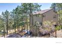 Exterior view of a home surrounded by trees and landscaped yard with stone pathway at 287 Brook Cir, Boulder, CO 80302