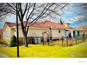 Home exterior featuring a well-maintained lawn and a wrought iron fence surrounding the property at 2977 Dunes Ct, Longmont, CO 80503
