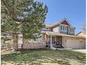 Charming two-story home featuring stone accents, a covered front porch, and a well-manicured lawn in a desirable location at 308 Elk Trl, Lafayette, CO 80026