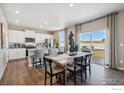 Open-concept kitchen and dining area with modern white cabinets and stainless steel appliances at 4201 Sandstone Dr, Mead, CO 80504