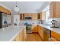 Spacious kitchen featuring stainless steel appliances, wooden cabinets, and white countertop island at 5292 Lichen Pl, Boulder, CO 80301