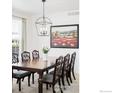 Formal dining room boasting a large dining table, modern lighting and wall art at 5861 Mt Shadows Blvd, Firestone, CO 80504