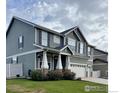 A charming two-story home with a well-manicured lawn and a three-car garage at 5861 Mt Shadows Blvd, Firestone, CO 80504