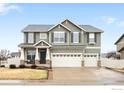 Charming two-story home with a three-car garage, manicured lawn, and stone accents at 5861 Mt Shadows Blvd, Firestone, CO 80504