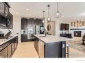 Open kitchen with an island, stainless steel appliances, and a seamless connection to the living area at 600 Grenville Cir, Erie, CO 80516