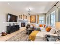 Comfortable living room with a stone fireplace, modern decor, and ample seating for relaxation and entertainment at 600 Grenville Cir, Erie, CO 80516