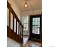 Warm entryway with wooden staircase and a front door, complemented by a window and decor at 6239 Willow Ln, Boulder, CO 80301