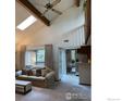 Sunlit living room with a vaulted ceiling, ceiling fan and a clear view into the kitchen at 6239 Willow Ln, Boulder, CO 80301
