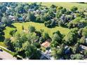 An aerial view shows the home nestled among trees, with a sprawling green space and neighborhood beyond at 6396 Twin Lakes Rd, Boulder, CO 80301
