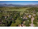 A landscape aerial view of the neighborhood with lush greenery, with mountains visible in the distance at 6396 Twin Lakes Rd, Boulder, CO 80301