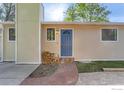 Inviting front entrance with a blue door, brick walkway, and stacked firewood at 6396 Twin Lakes Rd, Boulder, CO 80301