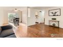 Open floor plan with hardwood floors, living and dining area leading to the white kitchen at 6396 Twin Lakes Rd, Boulder, CO 80301