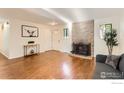 Bright living room with hardwood floors, a stone fireplace, and natural light at 6396 Twin Lakes Rd, Boulder, CO 80301