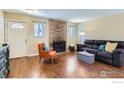 Cozy living room featuring a stone fireplace, hardwood floors, and comfortable seating with bright accents at 6396 Twin Lakes Rd, Boulder, CO 80301
