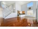 Spacious living room with hardwood floors, high ceilings, a staircase and an adjacent kitchen at 6433 Eagle Butte Ave, Frederick, CO 80516