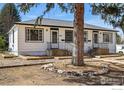 Charming home with updated landscaping, a cozy porch, and clearly visible house numbers at 809 Sunset St, Longmont, CO 80501