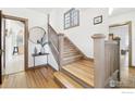 Traditional staircase with wooden floors and white walls and trim near a round mirror on a table at 861 13Th St, Boulder, CO 80302