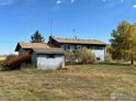 Side view of a two-story home with a storage shed in the backyard under a partly cloudy sky at 937 Glenview Dr, Berthoud, CO 80513