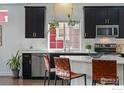 Modern kitchen featuring sleek countertops, stainless steel appliances, and stylish bar stool seating at 125 Indian Peaks Dr, Erie, CO 80516