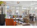 Bright living room boasts hardwood floors, large windows, and cozy seating arrangement at 125 Indian Peaks Dr, Erie, CO 80516