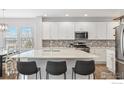 Modern kitchen with white cabinets, light countertops, and bar seating at the center island at 1458 Lander Ln, Lafayette, CO 80026