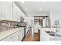 Well-lit kitchen features stainless steel appliances, white cabinets, and a subway tile backsplash at 1458 Lander Ln, Lafayette, CO 80026