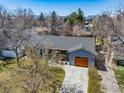 Aerial view featuring home with large, wooden garage door, mature trees, and mountain views at 1529 Washington Ave, Louisville, CO 80027