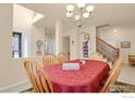 Bright dining room featuring a chandelier, adjacent to the staircase at 1533 Bellflower Dr, Brighton, CO 80601