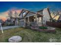 Two-story home featuring a three-car garage, welcoming front porch, and landscaped front yard at 1831 Ashford Cir, Longmont, CO 80504