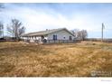 A lovely backyard with an expansive grassy area, a well-kept deck, and attractive landscaping, great for leisure and enjoyment at 20995 County Road 28, Hudson, CO 80642