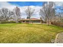 Expansive backyard featuring a lush lawn and mature trees, perfect for outdoor activities and relaxation at 2205 Lake Park Dr, Longmont, CO 80503