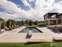Stunning pool with diving board, lounge chairs, and outdoor entertainment area on a sunny day at 2600 High Prairie Way, Broomfield, CO 80023