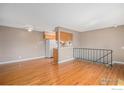 Open-concept living area with hardwood floors, a ceiling fan, and a breakfast bar connecting to the kitchen at 3354 S Flower St # 68, Lakewood, CO 80227