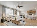 Cozy living room that flows into the kitchen with a center island at 4211 Sandstone Dr, Mead, CO 80504