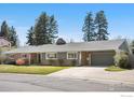 Street-level view of a single-story home with attached garage, lawn, and mature trees at 545 S Harrison Ln, Denver, CO 80209