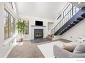 Open living area featuring a fireplace, vaulted ceilings, modern staircase, and large windows at 5904 Gunbarrel Ave # B, Boulder, CO 80301