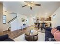 Open-concept living area showcasing hardwood floors, a staircase, and seamless flow into the adjacent kitchen at 61 Avocet Ct, Longmont, CO 80501