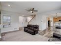 Open-concept living room with wood floors, neutral walls, and a staircase to the second floor at 637 Millet Cir, Brighton, CO 80601