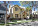 Attractive two-story yellow house with metal roof and inviting front porch at 832 Neon Forest Cir, Longmont, CO 80504