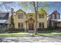Inviting two-story yellow home featuring a classic design and well-maintained front yard on a tree lined street at 832 Neon Forest Cir, Longmont, CO 80504