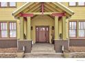 Welcoming front porch featuring sturdy support columns, stone steps, and a solid wood front door with sidelights at 832 Neon Forest Cir, Longmont, CO 80504