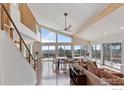 Bright, open living room featuring hardwood floors, high ceilings, and a wall of windows with scenic views at 8654 Thunderhead Dr, Boulder, CO 80302