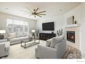 Spacious living room featuring a fireplace, ceiling fan and large television at 9283 Sedalia St, Commerce City, CO 80022