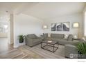 Bright living room with neutral decor, wood floors, and stylish furnishings at 9283 Sedalia St, Commerce City, CO 80022