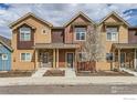 Beautiful townhome exterior featuring tan siding, stone accents, and a well-maintained front yard at 1240 Wren Ct # I, Longmont, CO 80501